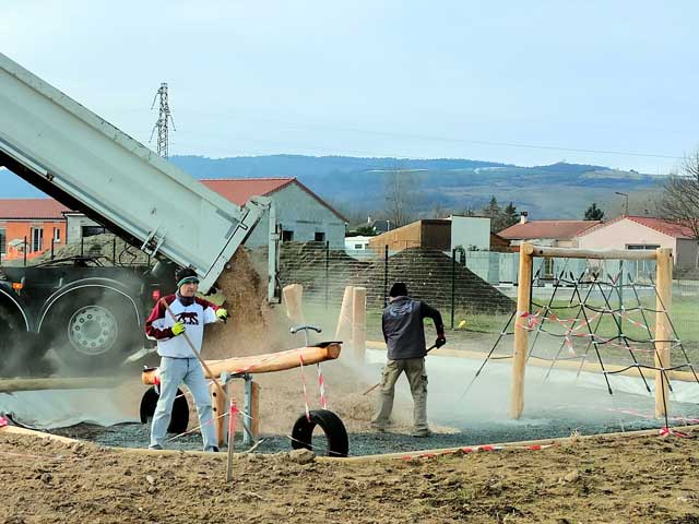 Pose de copeaux de bois sur une aire de jeux